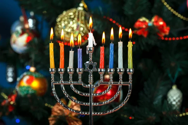 Yedi Kollu Şamdan mumlar için Hanukkah yılbaşı ağaç arka plan üzerinde ile