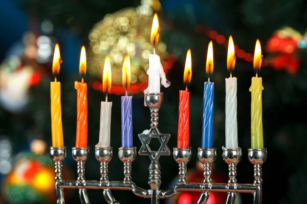 Menorah med ljus för Hanukkah på bakgrunden av trädet nyår — Stockfoto
