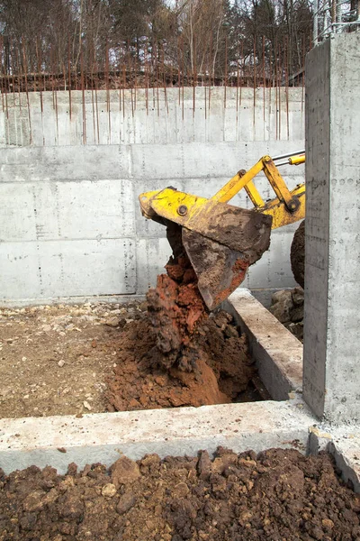 El tractor vierte la tierra para nivelar los cimientos . —  Fotos de Stock