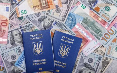 İki Ukrayna biyometrik pasaportu, dünyanın farklı ülkelerinden gelen para birimlerinin arka planına, avro, dolar, hryvnias, forints 'e karşı yalan söylüyor. Yurtdışında turizm ve eğlence kavramı. Üst görünüm