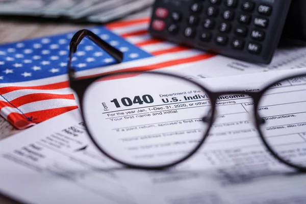 2020 tax return form 1040 with calculator and focus through glasses. The concept of filing a tax return, payment, return before April 2021