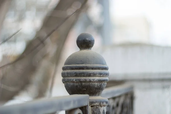 Metal ball on the fence. Close-up. Shallow depth of field.