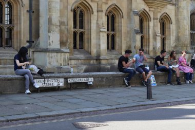 CAMBRIDGE, GREAT BRITAIN - SEPTEMBER 8, 2014: This is a scene near street signs on the parapet of one of the old buildings in the historic center of the town.