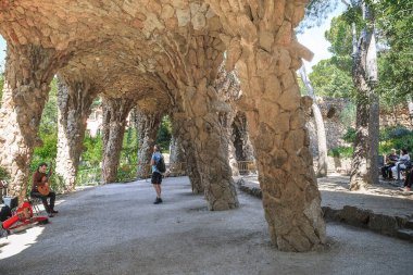 BARCELONA, SPAIN - 13 Mayıs 2017: Tanımlanamayan insanlar Park Guell 'de alışılmadık bir viyadük inşaatı altında gölgede bulunmaktadır (mimar Antonio Gaudi).