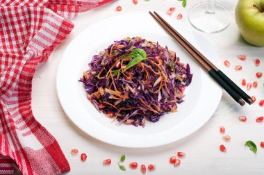 Vejetaryen kolay diyet (düşük kalorili) salata, kırmızı lahana, havuç ve nar tohumları Beyaz ahşap zemin üzerinde beyaz bir tabak içinde. Vegan, rawfoodist tarifi