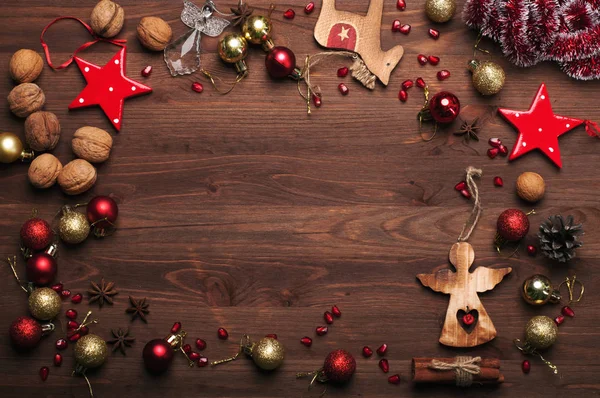 Ano Novo ou fundo de Natal (papel de parede). Decorações de Natal e ouropel, nozes, anis estrelado, cones de pinho, paus de canela e outros atributos de Natal em fundo de madeira marrom. Espaço para texto — Fotografia de Stock