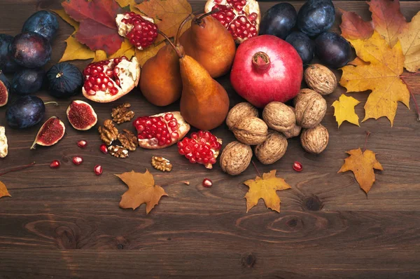 Fundo de outono (papel de parede) com frutas, como figos, peras e romãs, e nozes. Vegetariano, conceito vegan. Espaço para texto — Fotografia de Stock