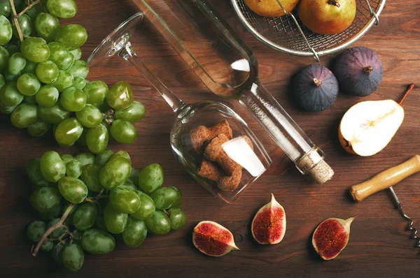 葡萄酒消费文化的概念。颈部的酒瓶，玻璃，葡萄，无花果，软木塞.和开瓶器棕色木制背景上. — 图库照片