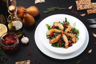 Roka, kızarmış armut ve karanlık bir arka plan üzerinde kurutulmuş domates salatası. Sonbahar salatası ev yapımı enfes. Vejetaryen, vegan kavramı