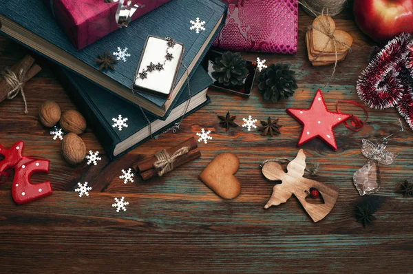 クリスマスと新年の壁紙 (背景)。ギフト、ジンジャー クッキー、コーン、クリスマス ボール、スターアニス、シナモンと暗い木の表面にクリスマス休暇の他の属性。クリスマスの精神 — ストック写真