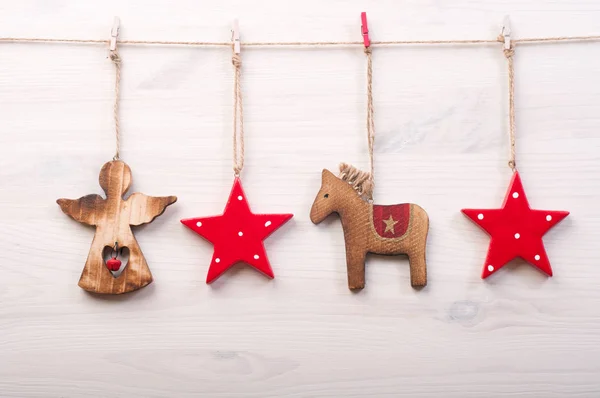 Noël et Nouvel An papier peint (fond). Jouets de Noël dans un style scandinave, comme les étoiles rouges, un cheval et un ange sur une surface en bois blanc . — Photo