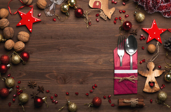 Christmas and New Year wallpaper (background). Gifts, ginger cookies, cones, Christmas balls, star anise, cinnamon, and other attributes of the Christmas holidays on the dark wooden surface. Spirit of Christmas