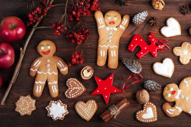 Noel ve yeni yıl duvar kağıdı (arka plan). Zencefilli kurabiye adam, Noel oyuncaklar ve süslemeleri, fındık, tarçın, anason ve diğer öznitelikleri Noel kahverengi ahşap zemin üzerinde.