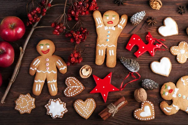 Jul och nytt år tapeter (bakgrund). Pepparkaksgubbe, jul leksaker och dekorationer, nötter, kanel, anis och andra attribut för jul på brun trä bakgrund. — Stockfoto