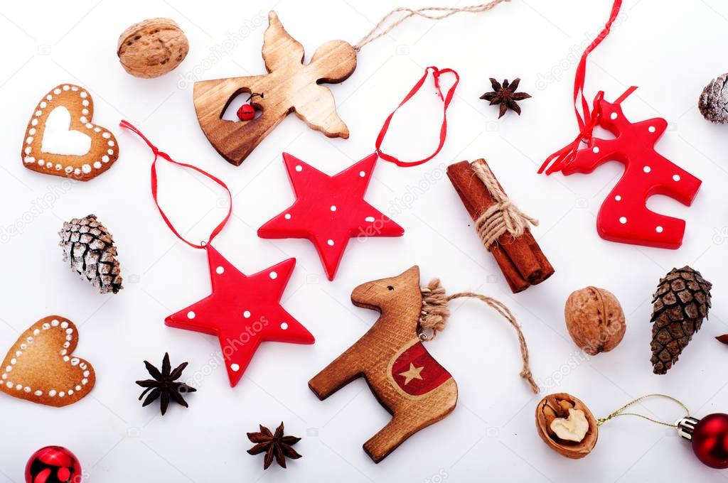 Christmas and New Year wallpaper (background). Christmas tree decorations (sets) in the Scandinavian style, such as red stars, figure of an angel and horse, bumps, spices and herbs on white wooden background. 