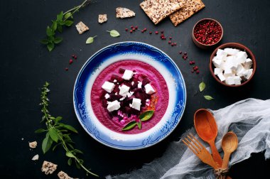 Pancar krem dilim beyaz peynir ve fesleğen ile karanlık bir yüzeye bırakır. Diyet çorbası - ev yapımı purees. Hafif öğle yemeği.