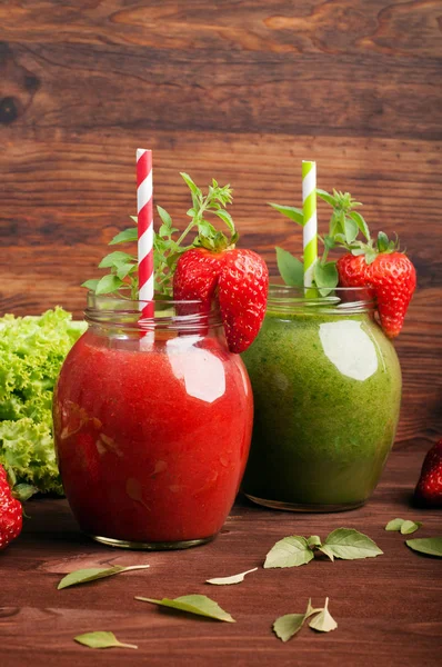 Trendy hipster ποτό σε φόντο καφετί ξύλινο. Κόκκινο μούρο smoothie με φράουλες και πράσινο smoothie του μήλα, αβοκάντο και το σπανάκι. Χώρο για το κείμενο. Υγιεινά και νόστιμα διαιτητικά ποτά για αποτοξίνωση — Φωτογραφία Αρχείου