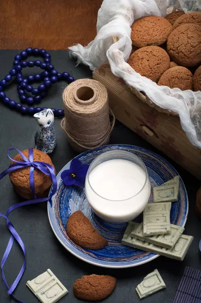 Food still life with oatmeal cookies, milk and white chocolate on a dark background. Useful and tasty breakfast or snack. Natural ingredients — Stock Photo, Image