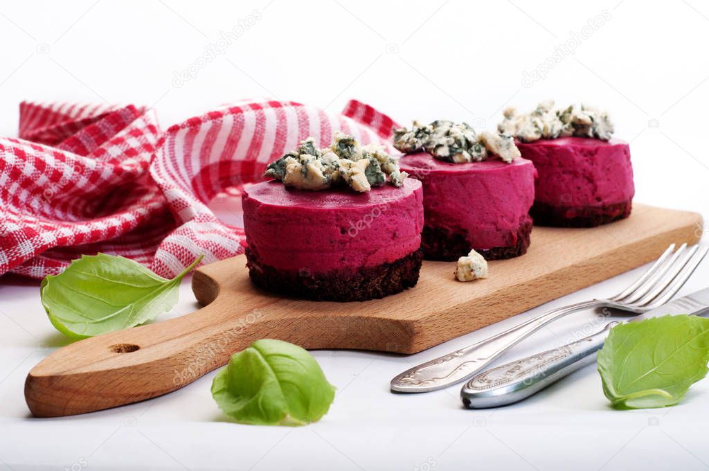 Beetroot mousse on rye diet bread, blue cheese on top on a white background. The concept of fusion food. Tasty appetizer diet.