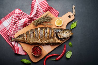 Baharatlar ve ahşap kesme tahtası üzerinde limon ile Tuna (balık) pişmiş. Çevre otlar ve baharatlar kekik, fesleğen ve pembe biber gibi. Diyet Akdeniz mutfağı.