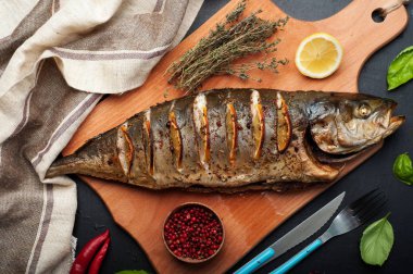 Baharatlar ve ahşap kesme tahtası üzerinde limon ile Tuna (balık) pişmiş. Çevre otlar ve baharatlar kekik, fesleğen ve pembe biber gibi. Diyet Akdeniz mutfağı.