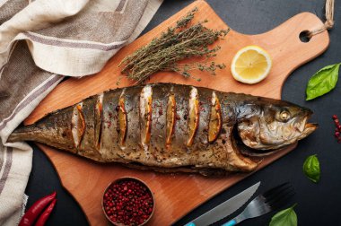 Baharatlar ve ahşap kesme tahtası üzerinde limon ile Tuna (balık) pişmiş. Çevre otlar ve baharatlar kekik, fesleğen ve pembe biber gibi. Diyet Akdeniz mutfağı.