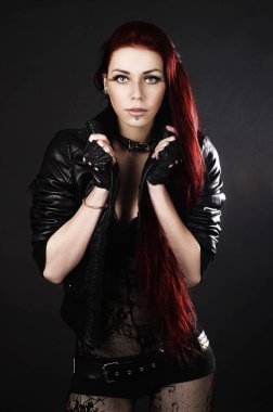 Dantel üst ve siyah arka plan üzerinde deri ceket duran uzun saçlı güzel genç kız. Stil 'rock and roll'. 'Moda ve Güzellik' kavramı. Bel portresi