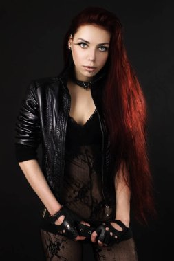 Dantel üst ve siyah arka plan üzerinde deri ceket duran uzun saçlı güzel genç kız. Stil 'rock and roll'. 'Moda ve Güzellik' kavramı. Bel portresi