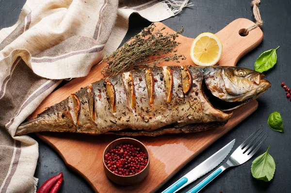 Atún (pescado) al horno con especias y limón en una tabla de cortar de madera. Cerca de hierbas y especias como tomillo, albahaca y pimienta rosa. Cocina mediterránea dietética . — Foto de Stock