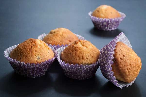 Muffin (cupcake) di cucina casalinga su una scura lavagna. Retroilluminazione. Sfondo sfocato . — Foto Stock