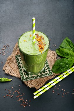 Elma, kivi, limon, ıspanak yaprakları ve yeşil çay karanlık bir yüzey üzerinde dışarı yeşil smoothies (sağlıklı diyet meşrubat). Vejetaryen, vegan kavramı. Metin için yer