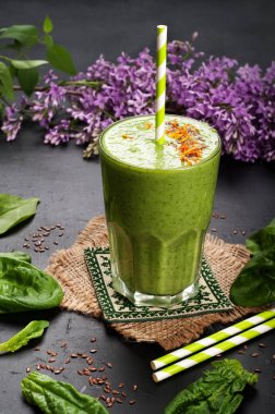 Elma, kivi, limon, ıspanak yaprakları ve yeşil çay karanlık bir yüzey üzerinde dışarı yeşil smoothies (sağlıklı diyet meşrubat). Vejetaryen, vegan kavramı.