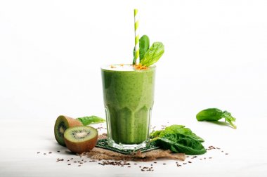 Yeşil smoothies (sağlıklı diyet meşrubat) elma, kivi, limon, ıspanak yaprakları ve yeşil çay beyaz bir yüzeye çıkar. Vejetaryen, vegan kavramı. Metin için yer