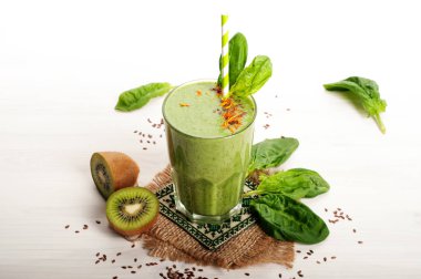 Yeşil smoothies (sağlıklı diyet meşrubat) elma, kivi, limon, ıspanak yaprakları ve yeşil çay beyaz bir yüzeye çıkar. Vejetaryen, vegan kavramı. Metin için yer