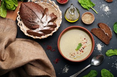 Düşük kalorili diyet çorbası ıspanak, patates, havuç ve soğan koyu arka plan üzerinde bir kil çanağı. Yapraklar ıspanak, zeytin yağı ve çavdar ekmeği. Vejetaryen, vegan kavramı.