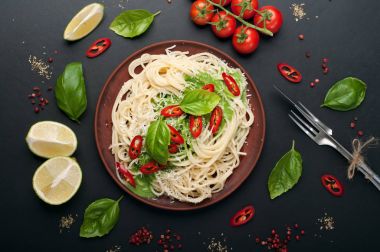 Fesleğen ve krema sosu, rendelenmiş peynir ve acı biber karanlık bir yüzeyi kil kahverengi tabakta parçaları ile makarna (makarna). İtalyan yemeği. Vejetaryen kavramı. Lezzetli ve sağlıklı yemek