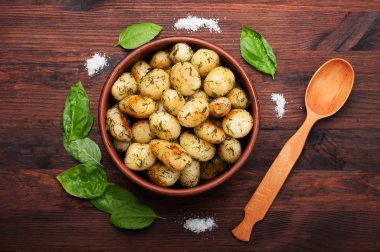 Altın bir kabuk ile genç patates kızartması bir kahverengi ahşap tahta üzerinde bir kil tabak içinde yalan. Vejetaryen kavramı