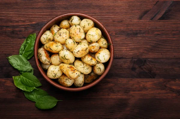 Altın bir kabuk ile genç patates kızartması bir kahverengi ahşap tahta üzerinde bir kil tabak içinde yalan. Vejetaryen kavramı