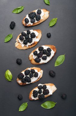 Krem peynir ve böğürtlen karanlık bir yüzeyi ile tost. Mevsim yaz sandviç.