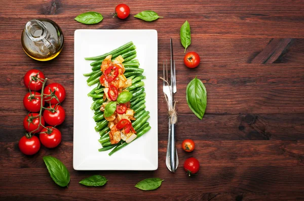 Spargelbohnen mit Paprika und Tomatensauce auf einem weißen rechteckigen Teller passieren. Kalorienarmes veganes Gericht — Stockfoto