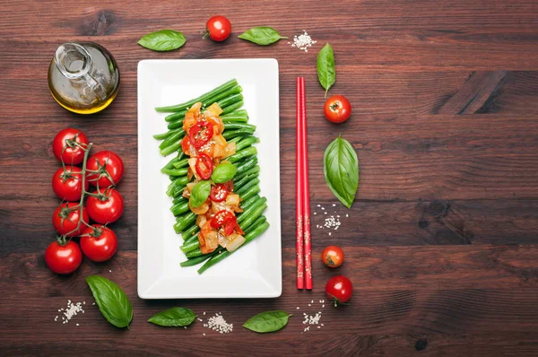 Biber ve domates sosu ile kuşkonmaz fasulye dikdörtgen beyaz tabak içinde geçti. Düşük kalorili diyet yemek. Vejetaryen, vegan kavramı