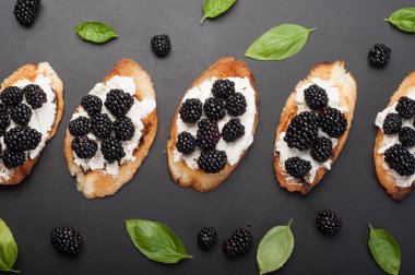 Krem peynir ve böğürtlen karanlık bir yüzeyi ile tost. Mevsim yaz sandviç. Makro çekim