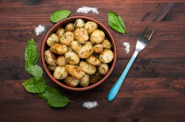 Tereyağı ve dereotu, koyu ahşap yüzey üzerinde kahverengi Kil çanak ile organik patates kızarmış. Lezzetli ve doyurucu ev yapımı yemek