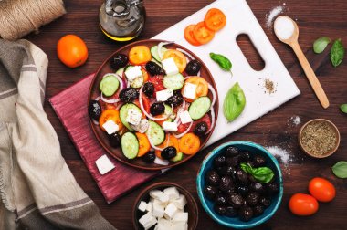 Akdeniz mutfağı. Domates, salatalık, mor soğan ve karanlık bir arka plan üzerinde kahverengi bir tabakta Sele zeytin salata. Füzyon Yunan salatası. Lezzetli ve sağlıklı mevsimlik yemek.