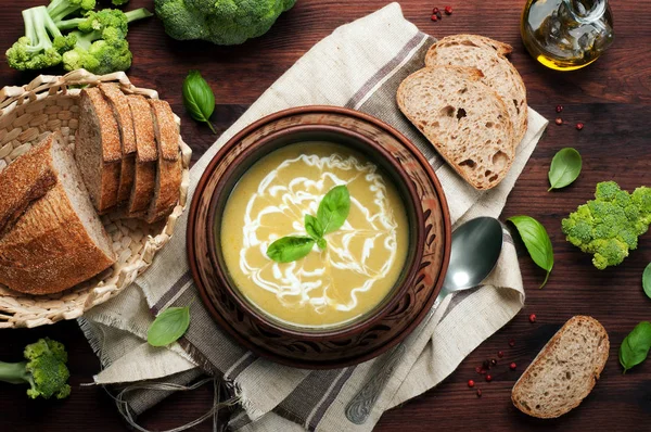 Caloriearm groentesoep van aardappelen, broccoli, uien, wortelen en kruiden in een kleiplaat op een donkere houten achtergrond. Een dieet schotel. Vegetarische, veganistische concept — Stockfoto