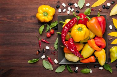 Sonbahar arka plan. Bir kare plaka üzerinde farklı çeşitlerinin sarı ve kırmızı biber. Çiğ sebze. Hasat gıda