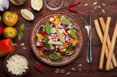 Salata çanak yapılmış domates, biber, salatalık, mor soğan, fesleğen yaprağı, süzme peynir, zeytinyağı ve limon suyu koyu ahşap arka plan üzerinde. Yararlı bir yemek. Sağlıklı beslenme, dengeli beslenme
