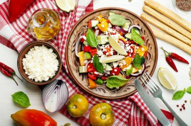 Salata çanak yapılmış domates, biber, salatalık, mor soğan, fesleğen yaprağı, süzme peynir, zeytinyağı ve limon suyu beyaz zemin üzerinde. Yararlı bir yemek. Sağlıklı beslenme, dengeli beslenme