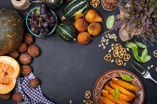 Sebze arka plan. Pumpkins, armut, ceviz, üzüm ve karanlık bir yüzey üzerinde heather çiçekler. Metin merkezi için yer. Hasat gıda — Stok fotoğraf