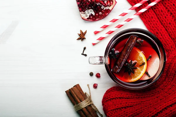 グリュー ワイン、リンゴ、オレンジ、スパイス、白い木製の背景の上に蜂蜜のスライスとガラスのコップ。冬クリスマスと新年を飲む — ストック写真